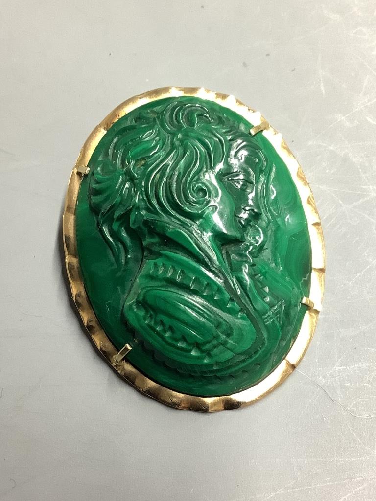 An oval malachite cameo brooch-cum-pendant, relief-carved with the profile portrait of a young girl, in 14K yellow gold mount